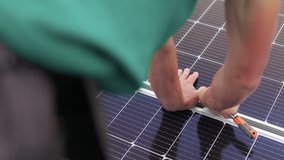 Installation, Connection and mounting of solar panels. Workers fasten solar panels. Technicians installing solar panels on metal stand. Workers installing PV solar panels on the roof of a house - Powered by Shutterstock - Get 15% off with code: PIKWIZARD15
