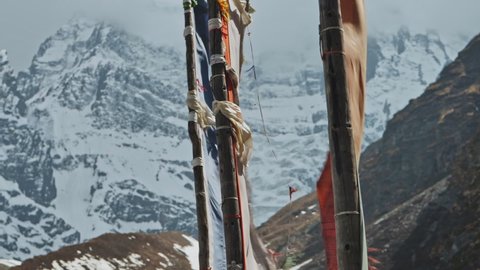 Wind blow, flags flap against severe cold snow wall of Annapurna III mountain, Nepal, Annapurna Circuit