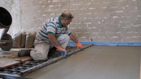 Construction worker smoothing concrete above the radiant floor system.