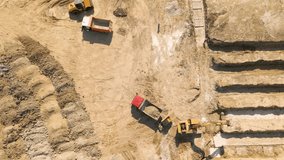 4K Video of a Crawler excavator working at the construction site. Top Aerial view of a Tracked Bulldozer Rides on Sandy Road.