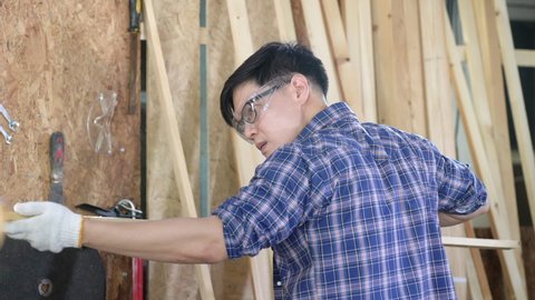 A carpenter is using a planer. Male carpenter using planer in wood workshop.