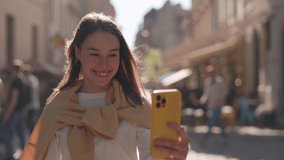 Charming young woman with hearing loss using sign language for telling Very happy for you during video call on smartphone. Modern gadgets for conversation.