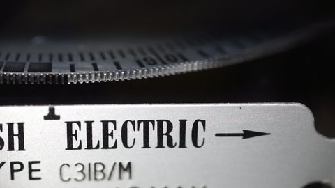 London, England, September 20th 2021: Macro close-up of electric meter dial edge, slow spinning measuring dial. Concept for energy supplier, bills, price rise, inflation and wholesale power.