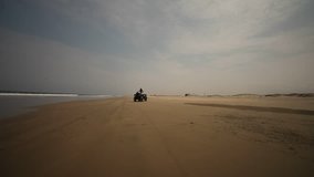 HD video footage. Woman drives a Quad. Mancora beach in south america, Peru.