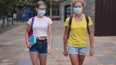 Youth teenager girls in face masks going from school after lessons.
