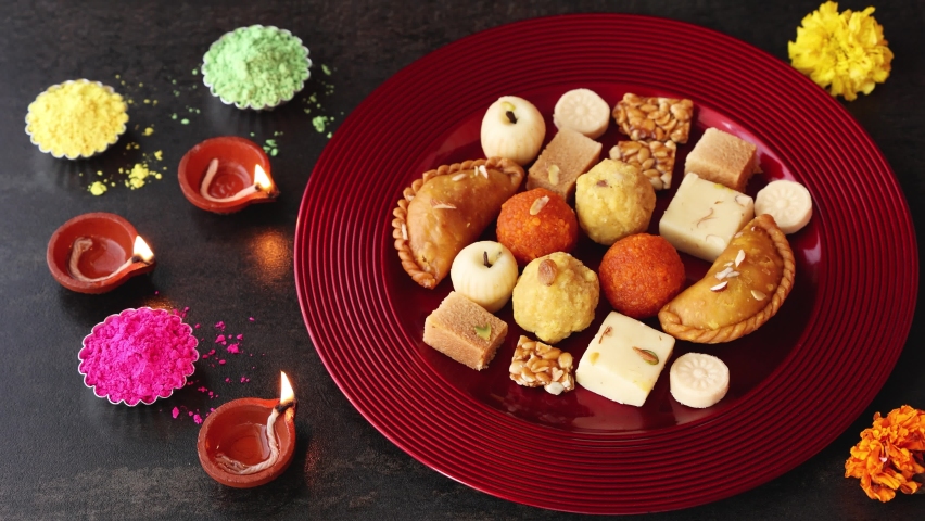Women hand taking mix of Indian sweet food specially made for festivals of India like Diwali Gujiya peda barfi Indian sweet dessert mithai festival Dussehra Holi Ganesh Chaturthi Ram Navami Durga | Shutterstock HD Video #1079448128