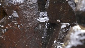 4K clip of water trickling down rocky surface