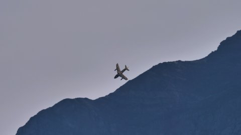 Mollis Switzerland AUGUST, 16, 2019 Low-altitude high-speed flight of cold war military jet with the crests of Alps as a backdrop. Hawker Hunter jet fighter aircraft of Swiss Air Force in tiger livery