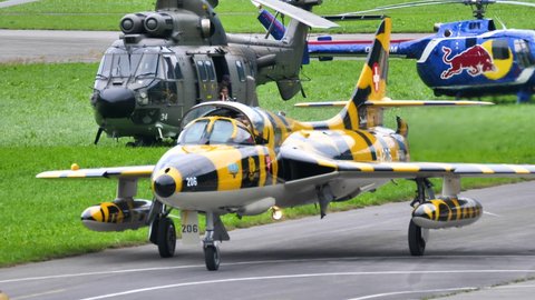 Mollis Switzerland AUGUST, 16, 2019 Close-up of a vintage aircraft of the cold war era in yellow and black tiger livery taxiing on airport runway. Hawker Hunter fighter jet of Swiss Air Force in 4K