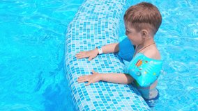 Joyful kid in a swimming pool. Little boy at swimming pool.  