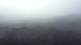 Drone video above the frozen lava of a volcano. Ash and snow