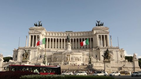 Monument to Victor Emmanuel II. Italy flags waving in the wind. Venice square in rome