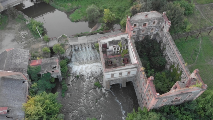 Old abandoned mill with waterfall. Water dam and bridge at beautiful old antique mill