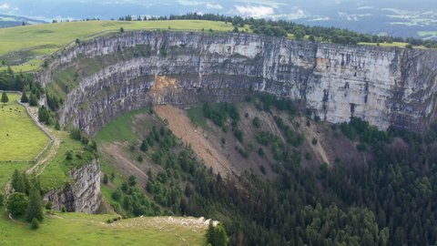 Wide drone shot of Creux du Van in Switzerland, located at the border of the cantons of Neuenburg and Vaud