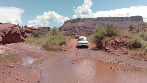 Moab , Utah , United States - 08 27 2021: White Range Rover truck drives through shallow river crossing, Utah