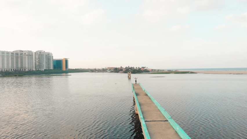 Aerial Over Adult Male Standing At End Of Broken Broken Bridge In Adyar, Chennai. Follow Shot