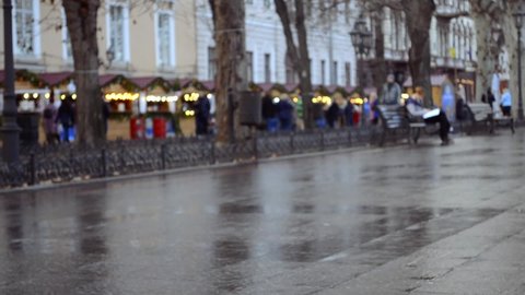 rainy city street in Odessa Ukraine in winter with soft focus, nondescript bicyclist
