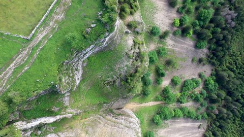 Downward angle drone shot of Creux du Van in Switzerland, located at the border of the cantons of Neuenburg and Vaud