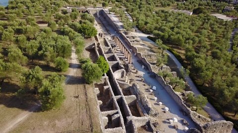 Cinematic 4K aerial drone video of the Archaeological site of Grotte di Catullo in Sirmione, a tourist destination with a castle, old churches and a roman villa on the shores of Lake Garda in Italy