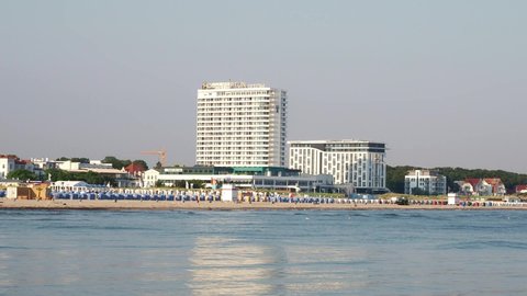 Rostock, Germany - July 12, 2021: Coastline of baltic sea and lighthouse of Warnemuende with Hotel Neptun