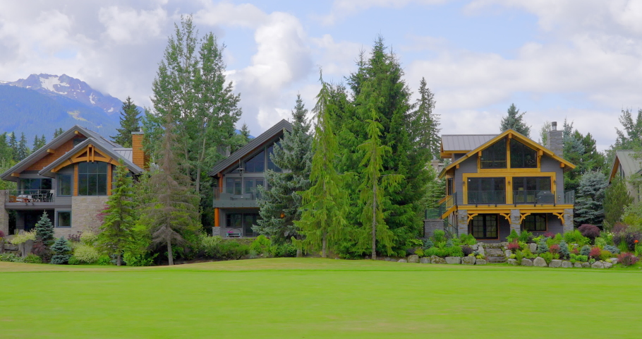 Establishing shot of two story luxury house with golf foreground, big tree and nice landscape in Vancouver, Canada, North America. Day time on June 2021. Slow tilt up. ProRes 422 HQ.