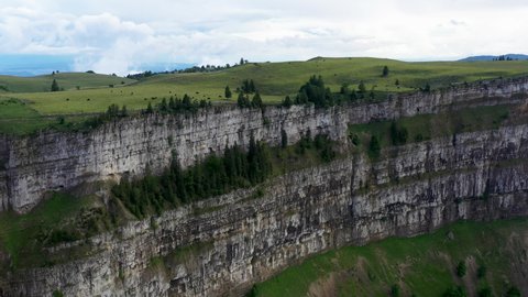 Drone shot of cliff walls at Creux du Van in Switzerland, located at the border of the cantons of Neuenburg and Vaud