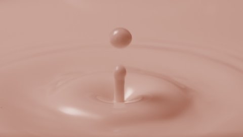 Macro shot of brown milk drop falls down on brown milk surface creating concentric circles on it | Foundation commercial