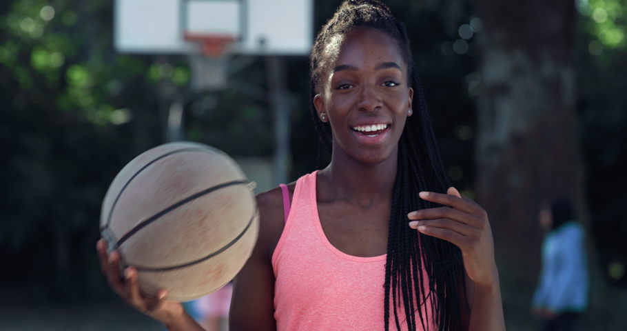 Portrait of Strong Black Young Woman Tossing a Basket Ball Around While Looking at the Camera in an Outdoor Court. Female Athlete Defying Stereotypes and Following her Dream of Going Professional  Royalty-Free Stock Footage #1079519513