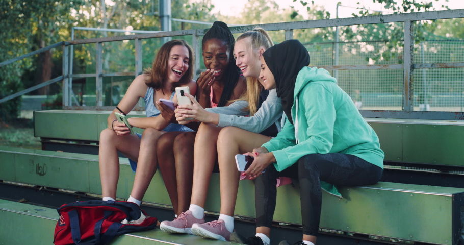  Group of Young Multiethnic Female Teenagers Sitting in a Public Park and Watching a Funny Video on Smartphone. Group of Friends Having Fun Together Outdoors While Staying Connected Royalty-Free Stock Footage #1079519918