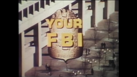 1970s: J. Edgar Hoover FBI building in Washington D.C.. Titles. Man gives tour to people inside building, points to list of crimes FBI covers. People on tour. People outside building, in offices.