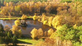 Wooden old fisherman house on small island in the autumn park. Bird's eye view. Location place of Zbrui village, Ukraine, Europe. Cinematic aerial shot. Beauty of earth. Filmed in 4k, drone video. 