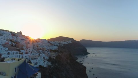 Fantastic sunrise on the legendary island of Santorini, Greece. Aerial video on a drone in the town of Oia, beautiful little white houses with blue roofs