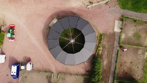 KUNGSBACKA, SWEDEN - September 19, 2021: Aerial top down view of a walking machine for horses on a farm on a sunny summer day. 4K drone video. Circulating above.
