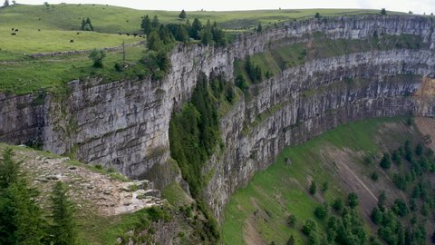 Cinematic drone shot of Creux du Van in Switzerland, located at the border of the cantons of Neuenburg and Vaud