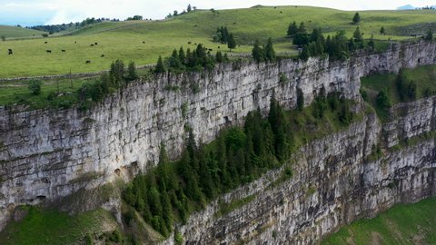 Revealing drone shot of Creux du Van in Switzerland, located at the border of the cantons of Neuenburg and Vaud