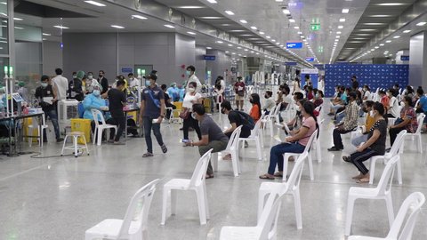 Vaccination center Queue of Thai and migrant workers one by one receive vaccine, waiting sit on chairs. COVID-19. 10bit 422. Bang Sue Railway Station Bangkok, Thailand 19 Sep 2021