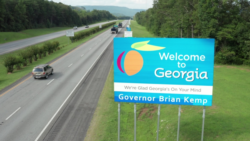 Dade County , Georgia , United States - 08 10 2021: Welcome to Georgia sign by interstate 59 highway in Dade County. Aerial on summer day. Mountains in distance.