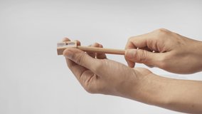 Hands shaving wooden pencil with pencil sharpener isolated on white background. Stationary items. - Powered by Shutterstock - Get 15% off with code: PIKWIZARD15