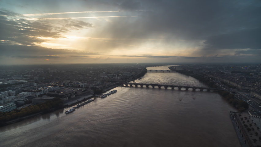 Establishing Aerial View Shot of Bordeaux Fr, light fog, Pont de Pierre, world capital of wine, Nouvelle-Aquitaine, France, wide push back