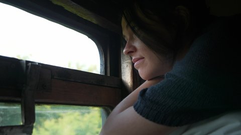 Woman Travel by Old Vintage Train Third 3rd Class Platzkart Car. Female Tourist Lying on Top Bunk Bed Shelf Looking at Window Watching Nature. 4K