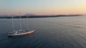 Aerial drone video of Cruise ship sails against a background of orange sunset