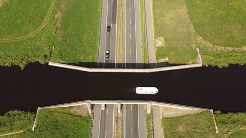 Aqeuduct water bridge with boats passing traffic on the highway below in Friesland, The Netherlands.