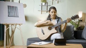 Professional musician teaching guitar in online class on digital tab - concept of virtual music training from home