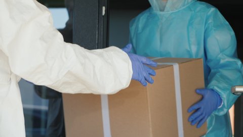 People in protective suits unload boxes of medicine