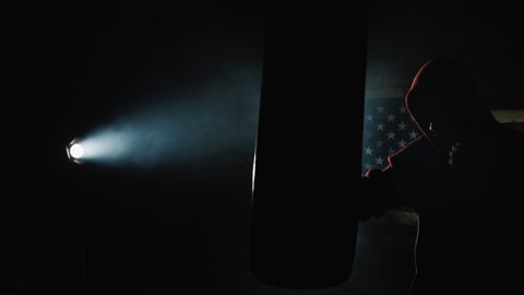 Boxer trains in the spotlight, in the background hangs an American flag