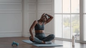 Fitness Workout. Black Sporty Woman Stretching Neck Muscles While Training At Home, Young African American Female Tilting Head To Side And Sitting In Lotus Position, Slow Motion Footage