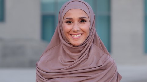 Close-up arabian human lady smiling toothy dental. Muslim female face portrait islam arab girl happy pretty islamic woman wears pink hijab millennial standing outdoors in city looking at camera smile
