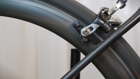 Rotating bike wheel, close up. Bicycle brake pads in details. Bike maintenance workshop. Bike service, repairing