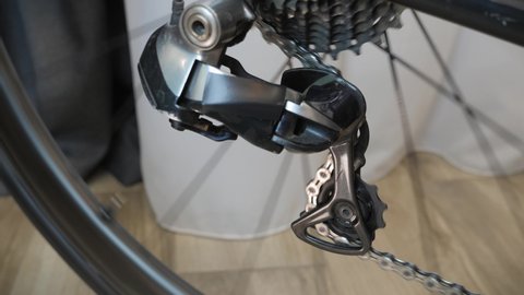 Bicycle gear changing. New cassette with gears and chain on the rear wheel. Bike transmission, close up. Work of chain drive, rear derailleur with cassette. Bicycle workshop