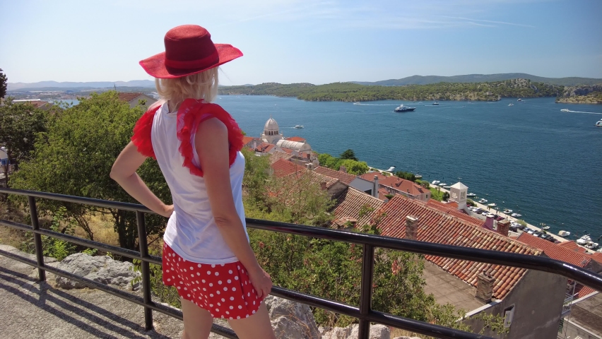 Woman looking from St. Michael Fortress, the port of Sibenik city with ferry boats ad cruise ships. Sibenik historic city of Croatia in Dalmatia by the river Krka. It was part of the Venice Republic.